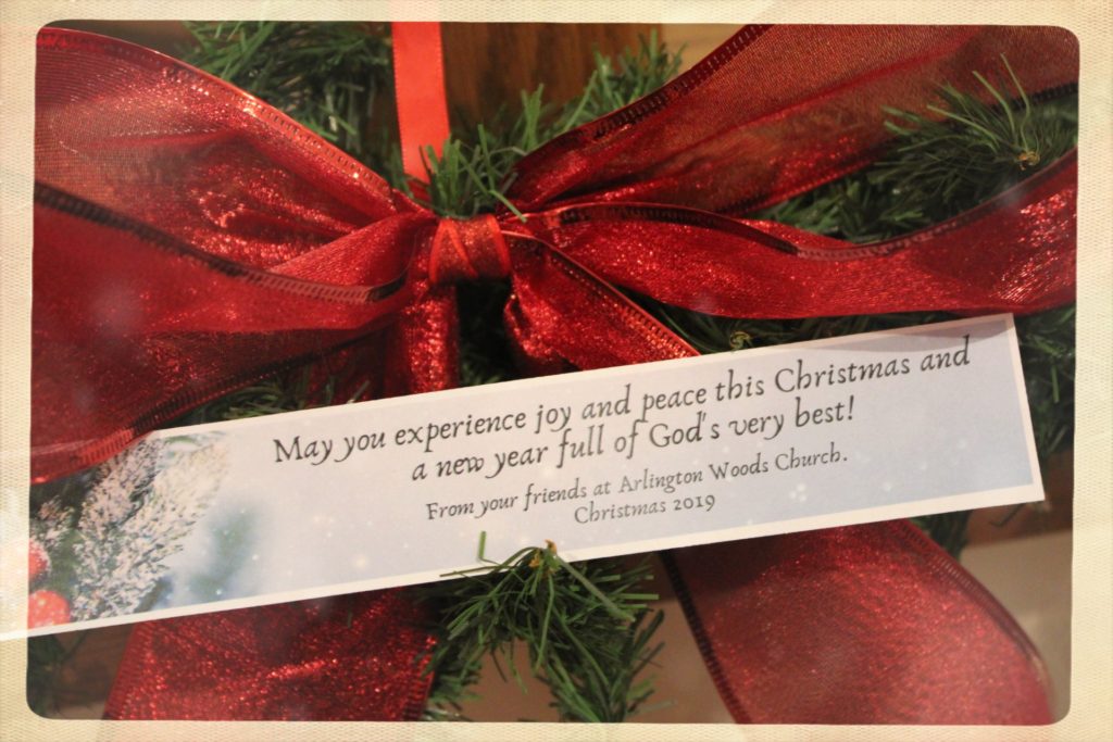 A Christmas note attached to wooden Christmas ornament.